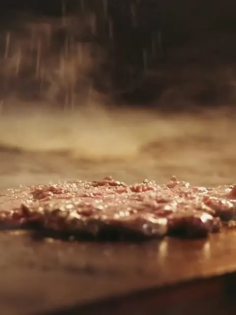 Bastidores: smash burger sendo prensado na chapa